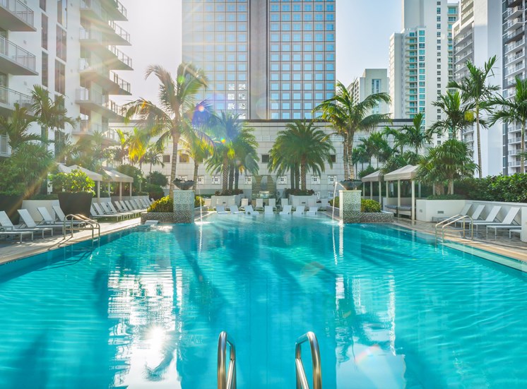 A large swimming pool with sunlight reflecting on the water.